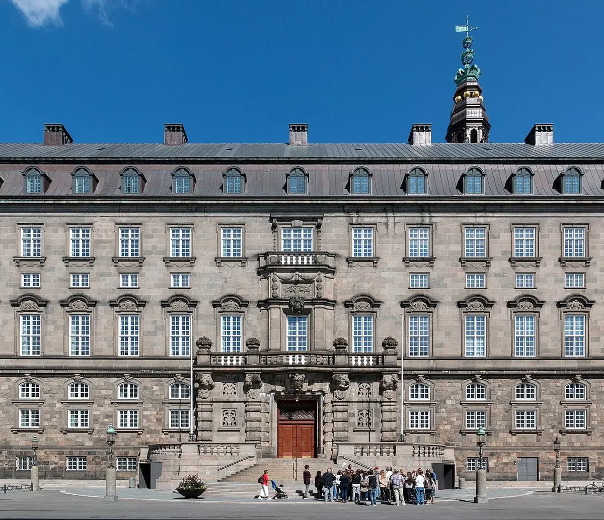 Exterior of the Danish Parliament building in Copenhagen with a group of people in front