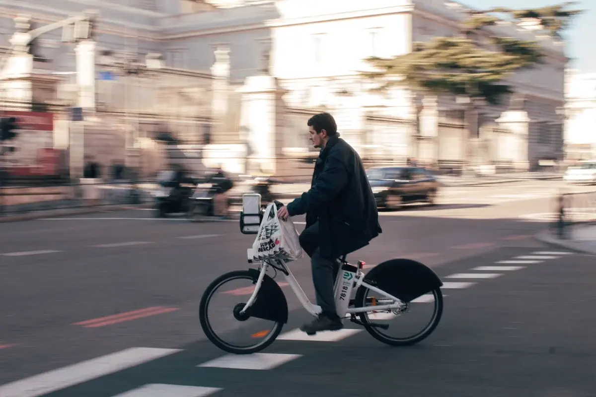 A man riding an electric bike on a city street in Madrid.