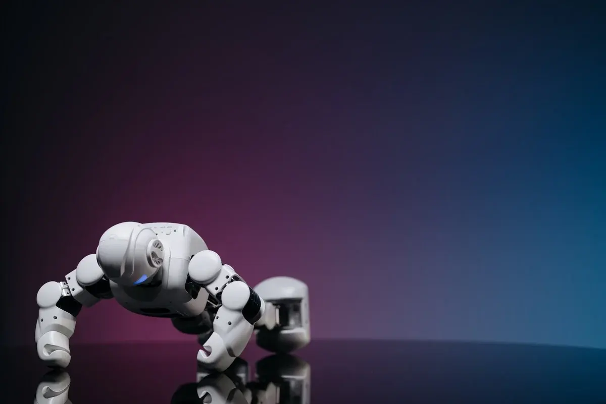 A white robot doing push-ups on a reflective surface.