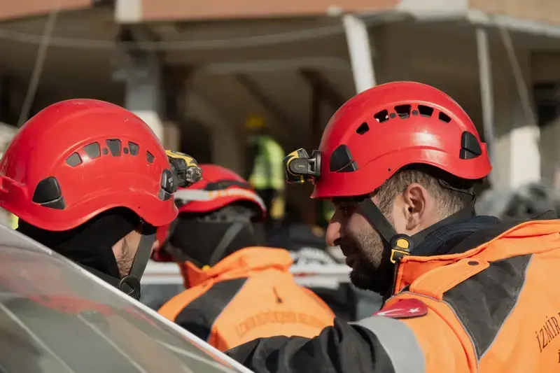 Rescue workers in helmets and orange jackets working during rescue operation