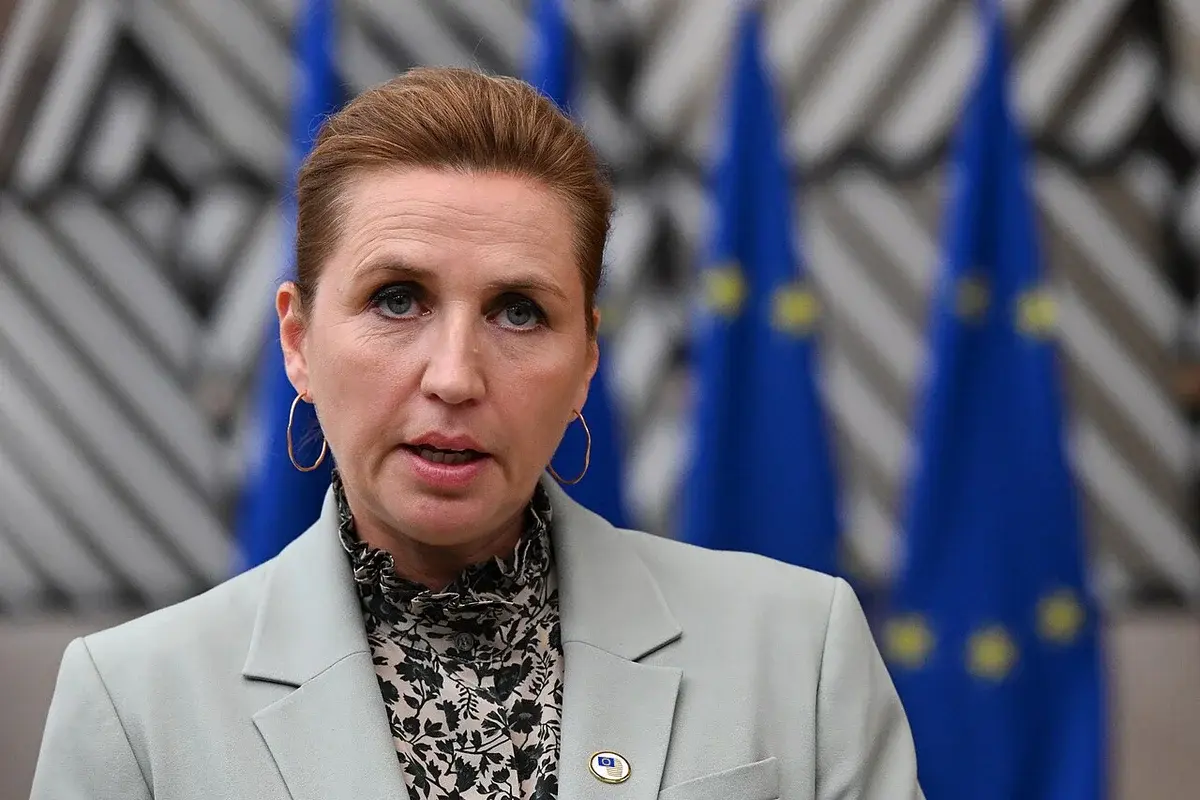 Mette Frederiksen speaking in front of EU flags.