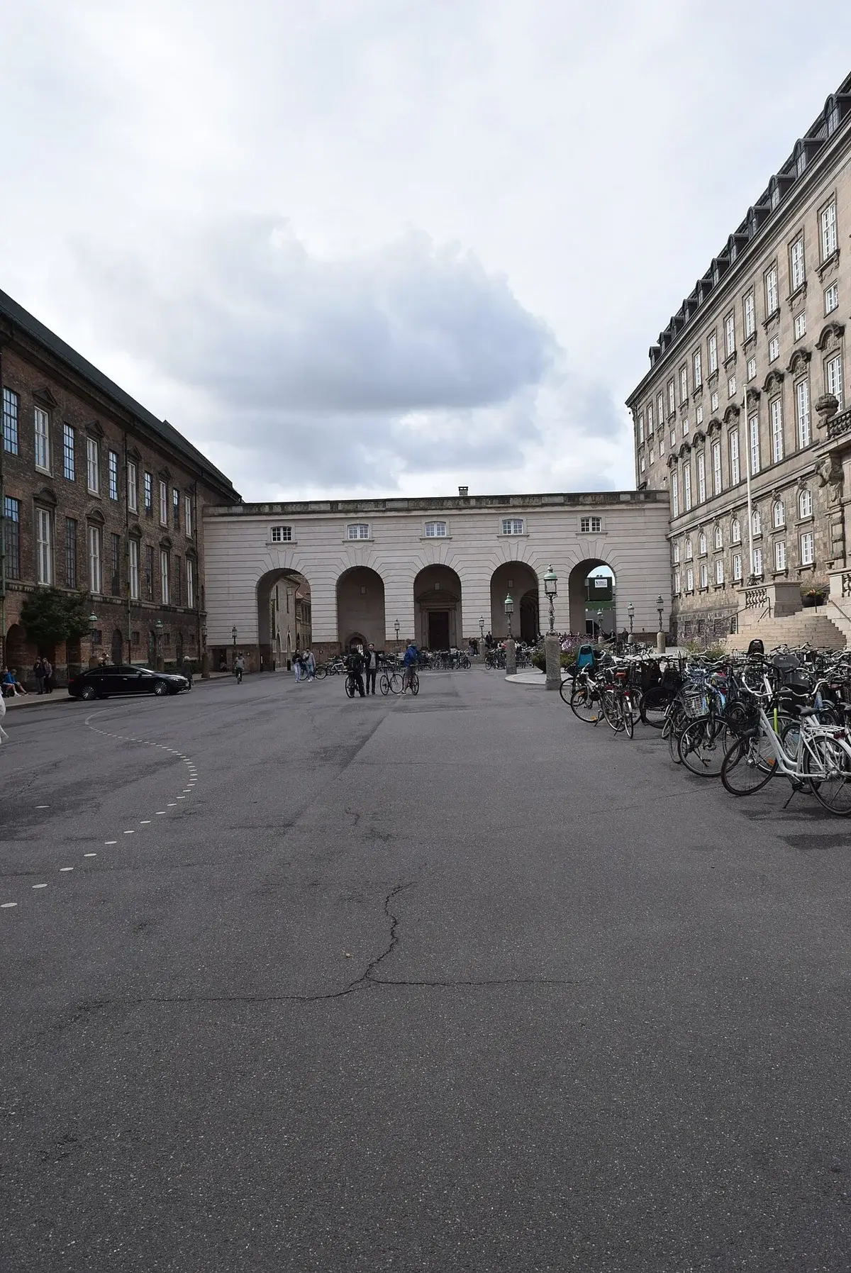 Christiansborg Palace courtyard in Copenhagen with bicycles and people.