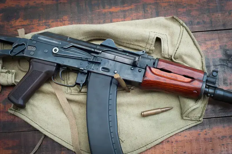Close-up of AK-47 rifle with ammunition on fabric bag