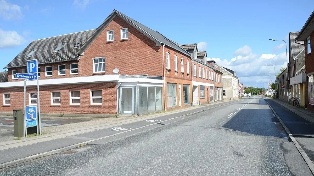 A quiet street in Holsted, Denmark, with brick buildings along Storegade.