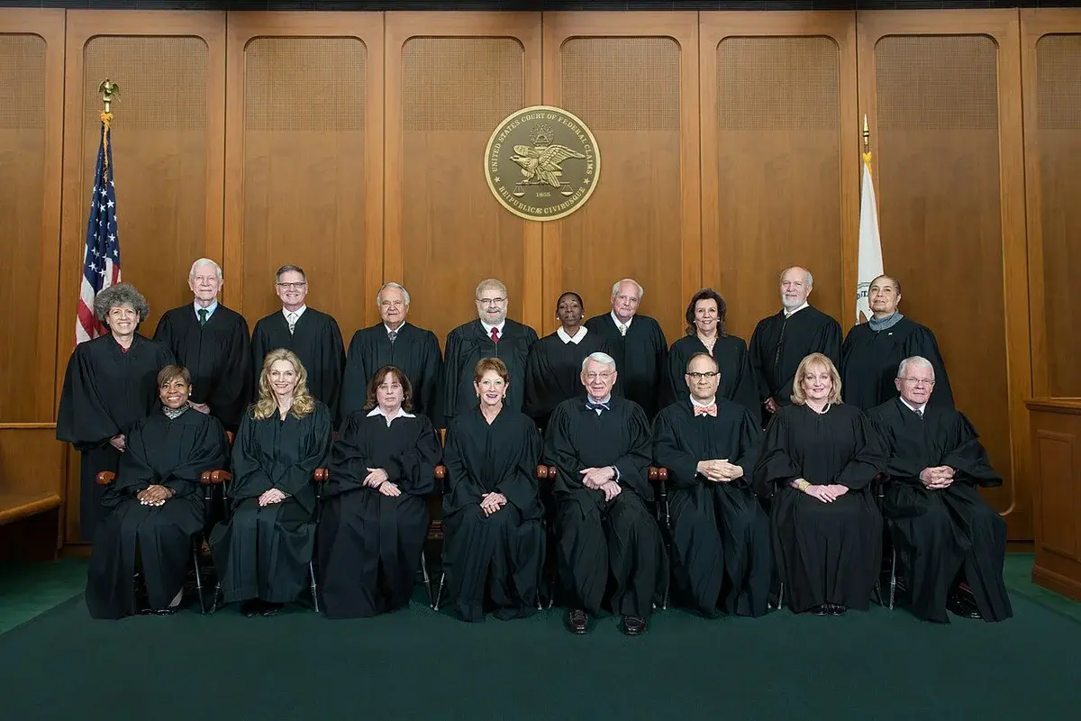 Group portrait of judges in robes inside a courtroom.