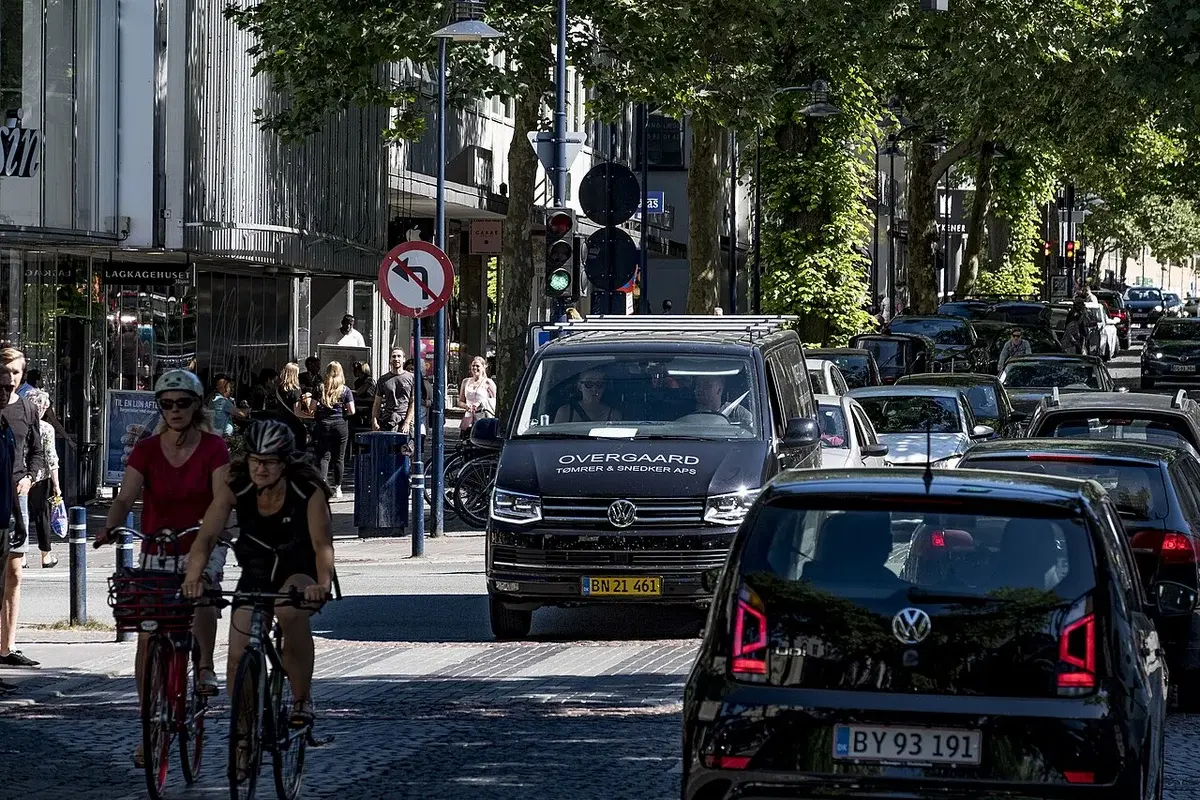 Busy street in Kongens Lyngby with cars, cyclists, and pedestrians.