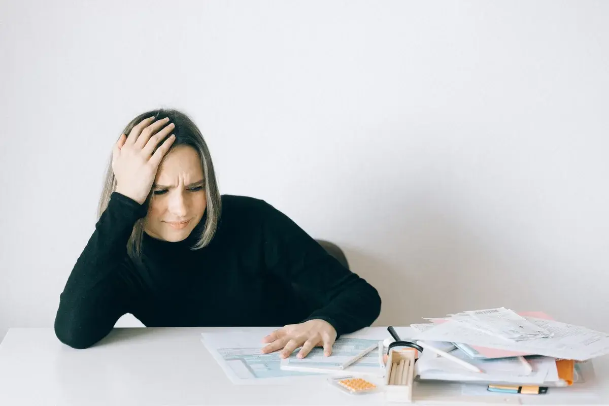 stressed woman with financial documents at table