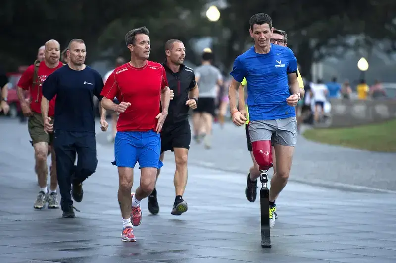 Group of men running outdoors, one with a prosthetic leg