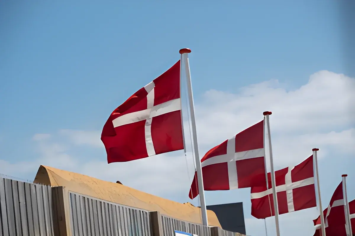 Danish flags waving on poles against sky