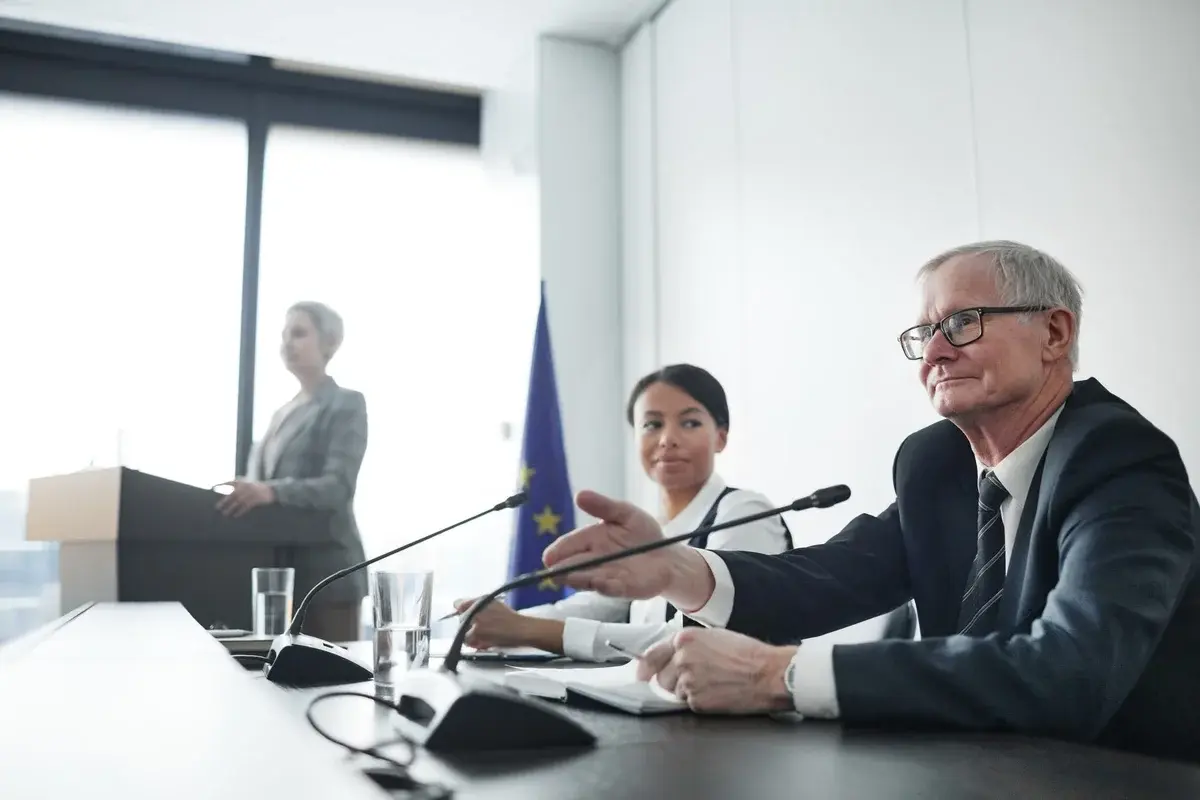 Panel discussion with professionals at a conference table and EU flag