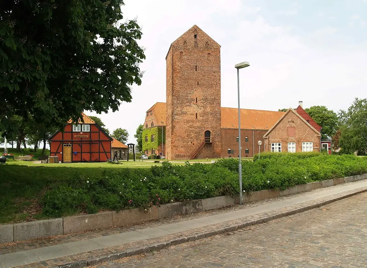 Historic fortress buildings with a tall brick tower in Korsør, Denmark.