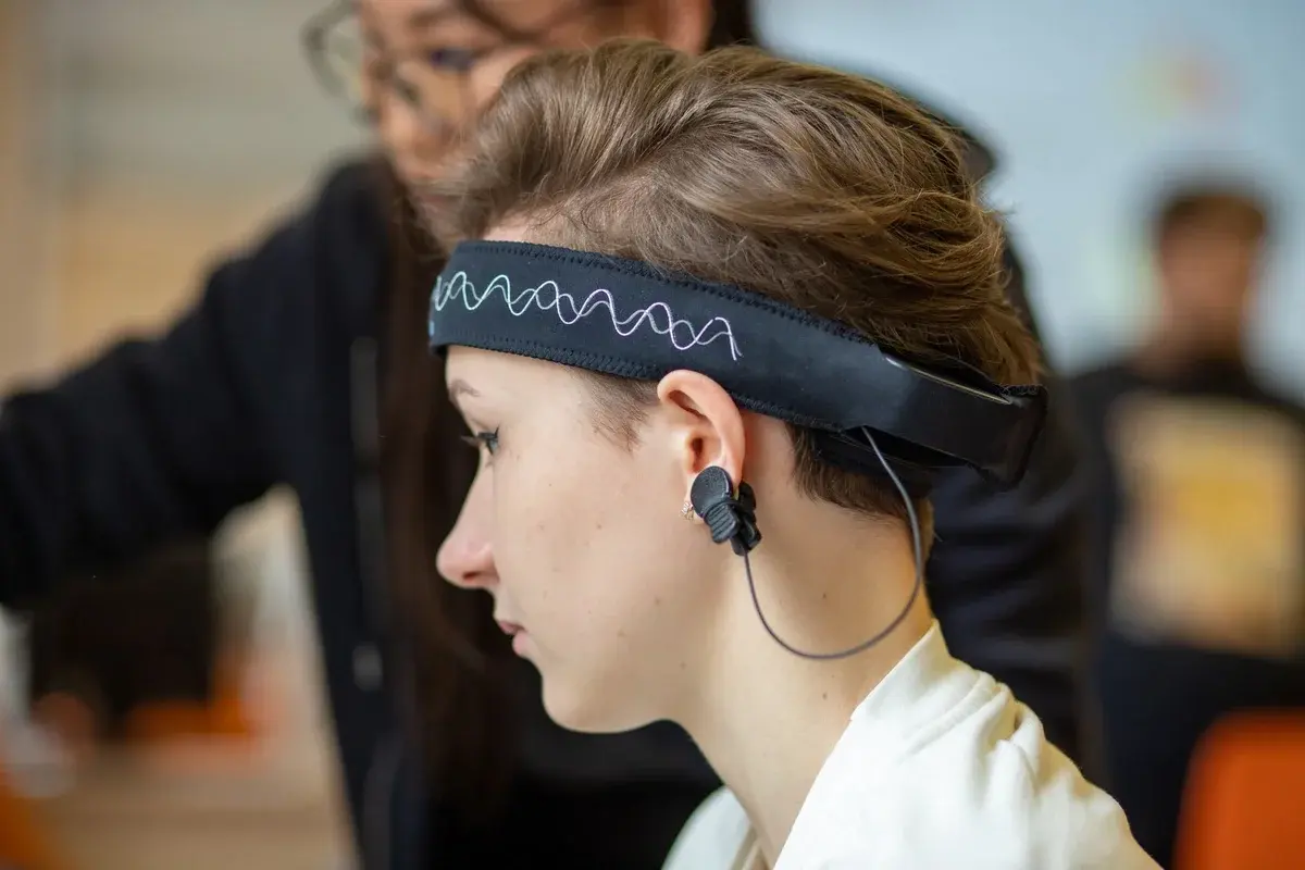 Young woman wearing an EEG headband indoors.