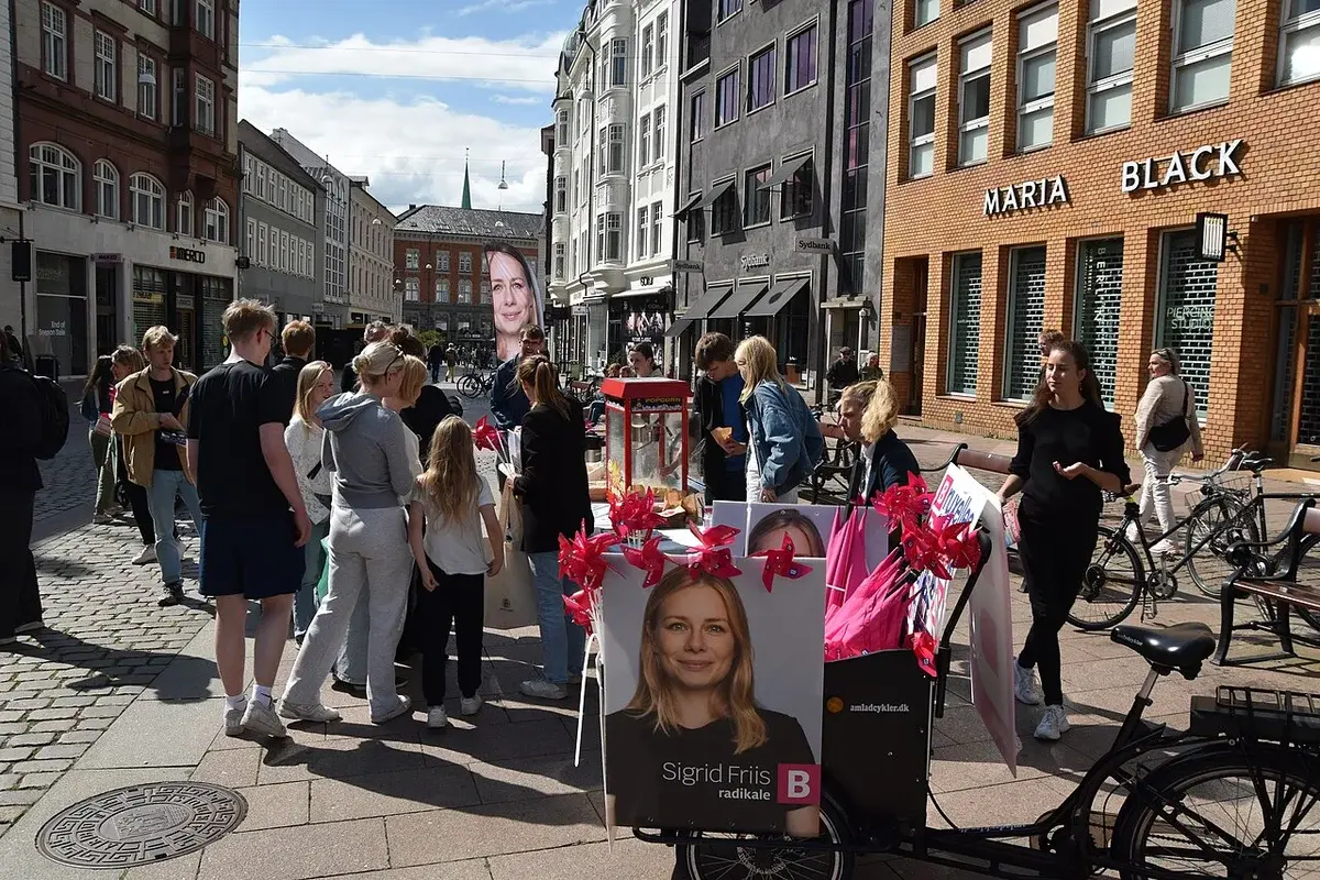 People campaigning with Radikale Venstre posters on a cobblestone street