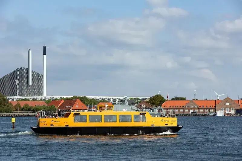 Yellow passenger ferry on water near city