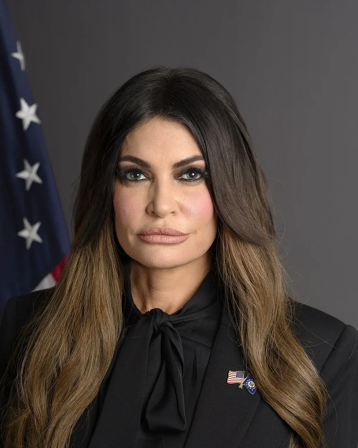 Official portrait of Kimberly Guilfoyle in front of an American flag.