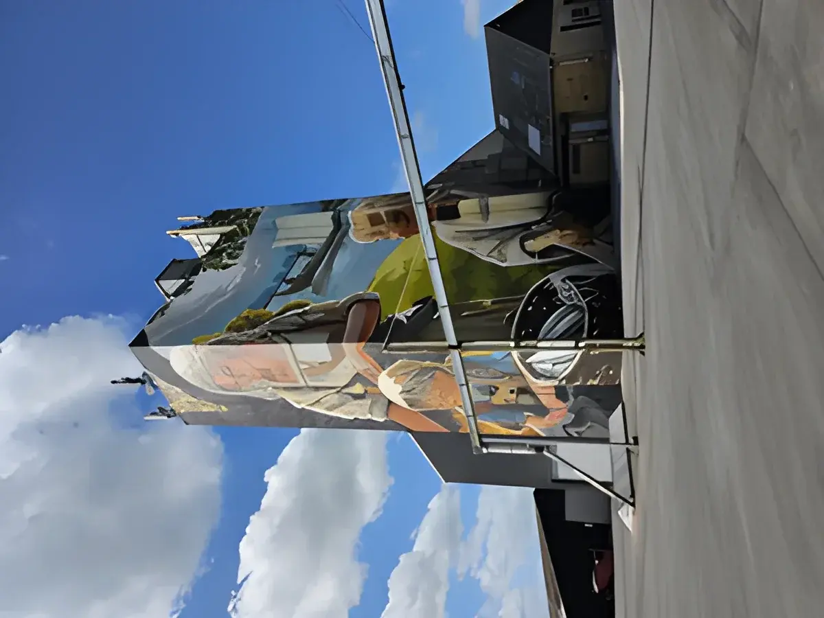 Building covered with a large mural against blue sky