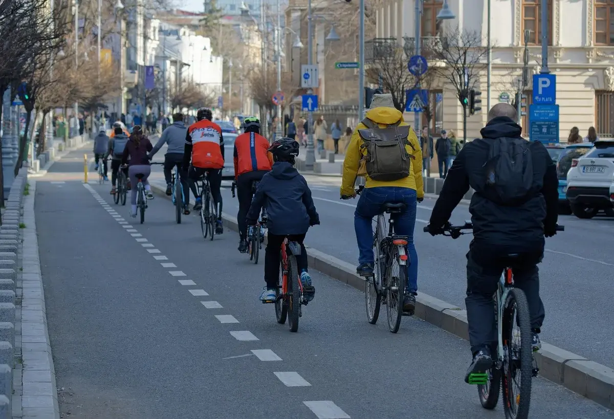 A group of cyclists riding along a city bike lane.