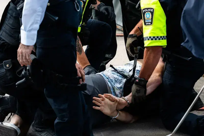 Police officers handcuffing a person on the ground