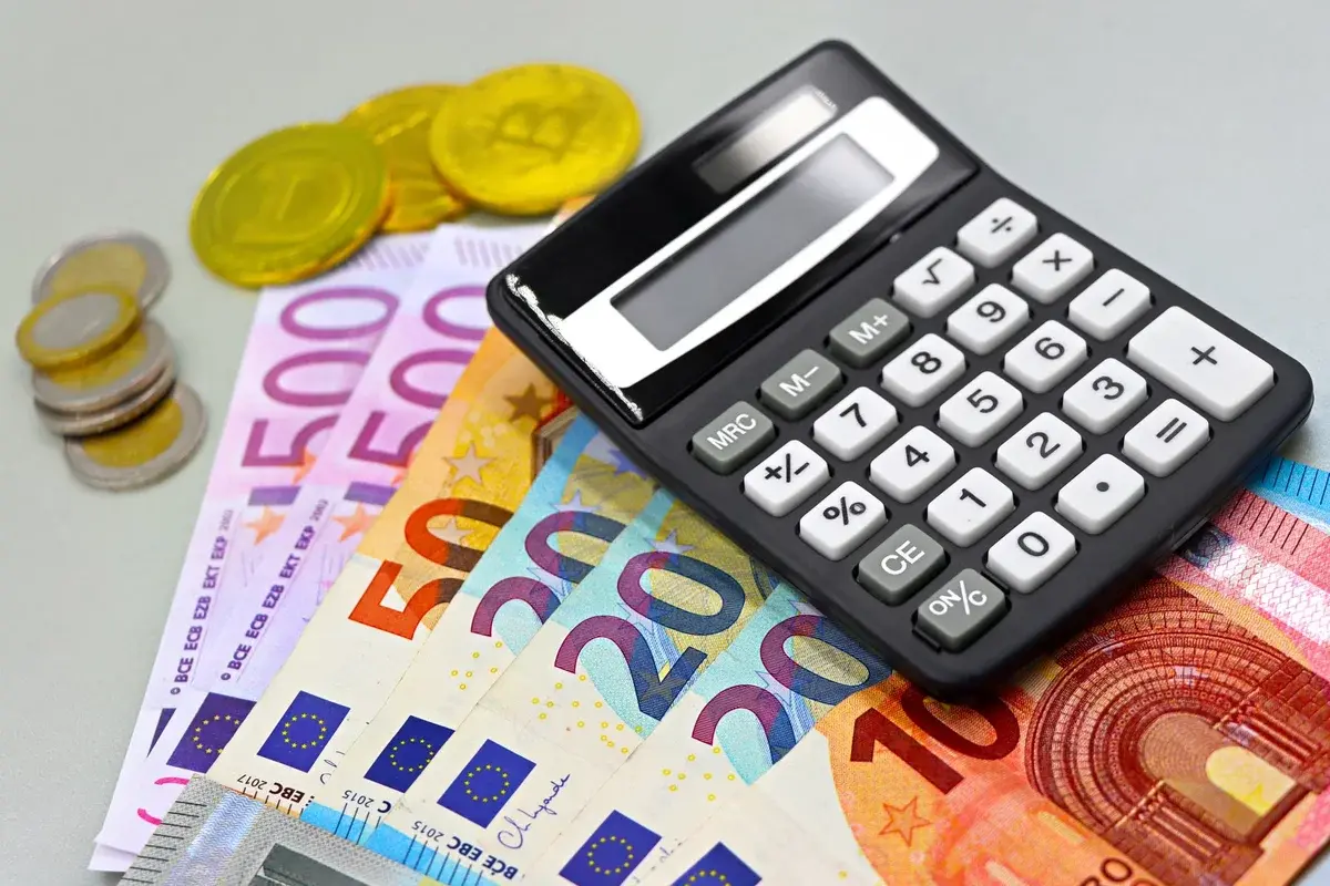 Euro banknotes and coins with a calculator