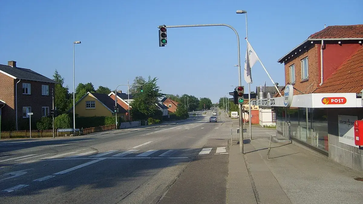 A main road with traffic lights and houses in Hasselager, Denmark.