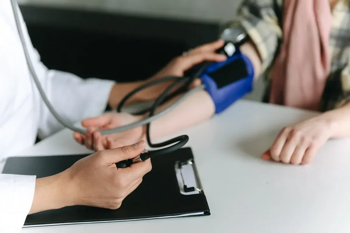 Close-up of a clinician taking a patient's blood pressure.