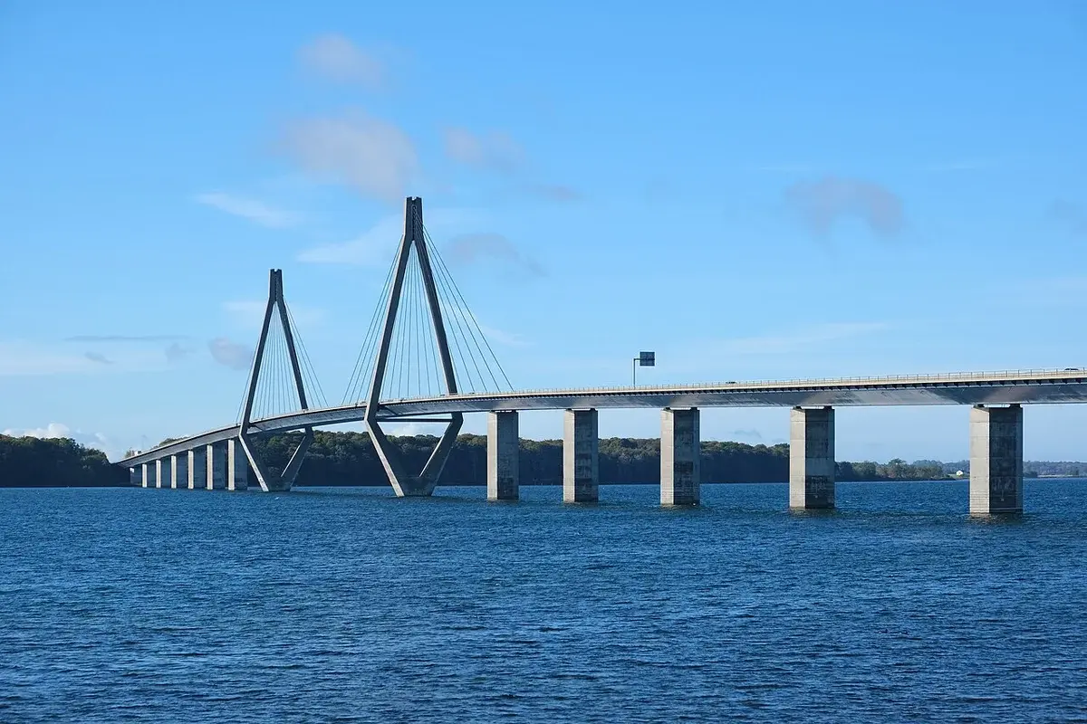 A cable-stayed bridge crossing water under a blue sky.