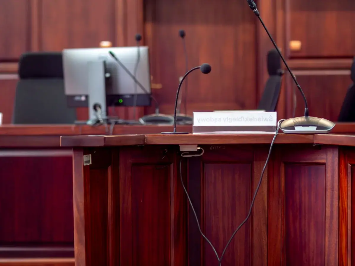 Wooden podium with microphones and nameplate in courtroom