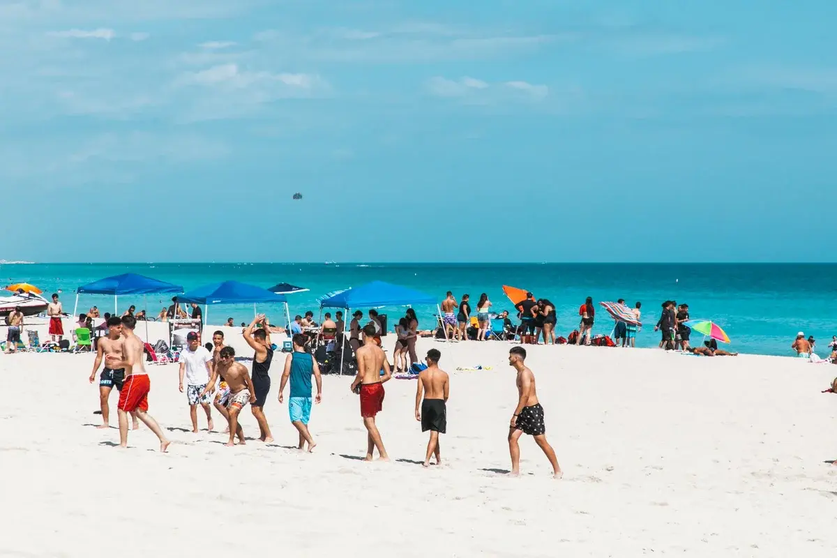 People enjoying sunny Miami Beach with blue sky and ocean