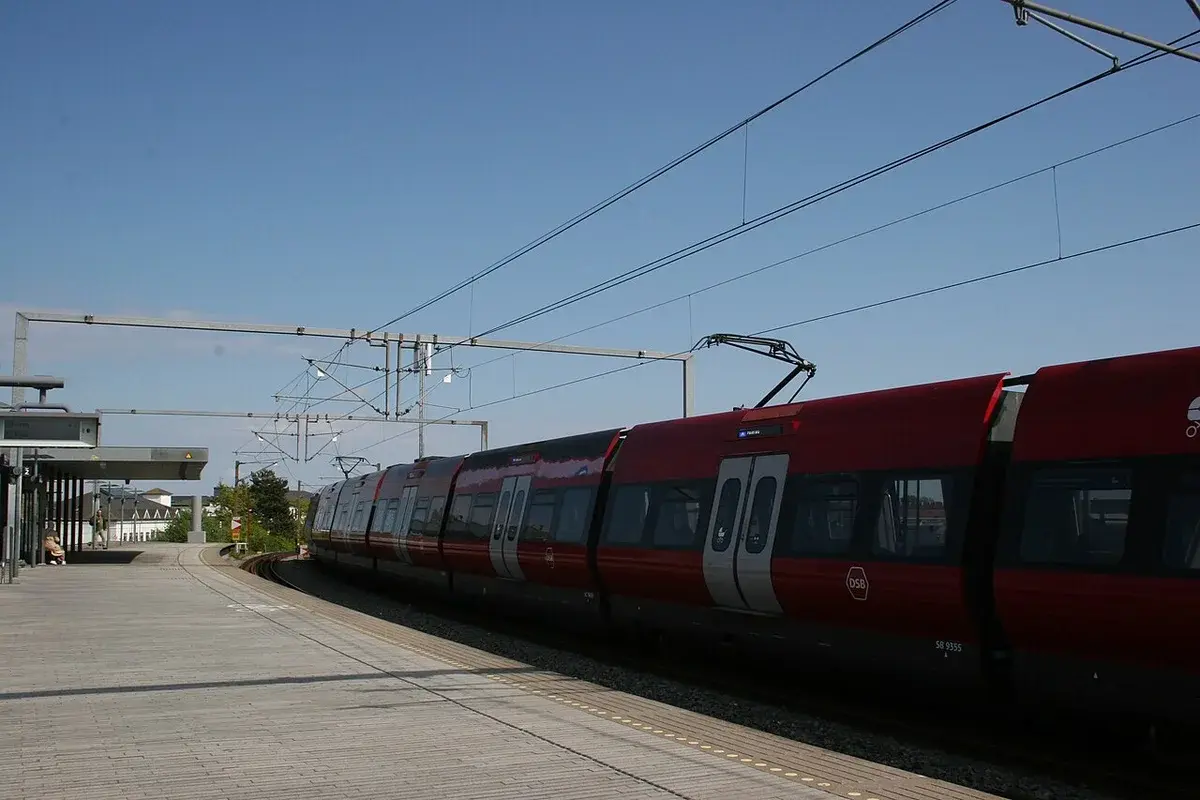 A red S-train at a station platform in Copenhagen.
