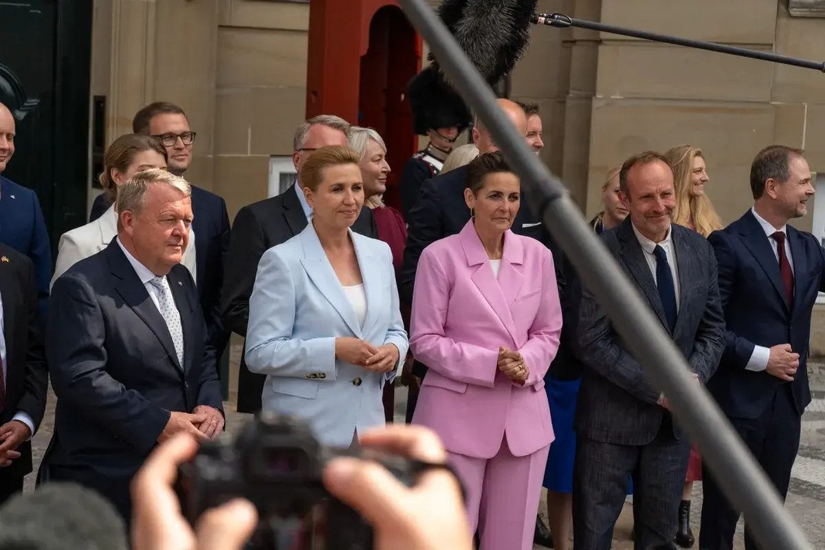Danish political leaders standing together during a government presentation ceremony.