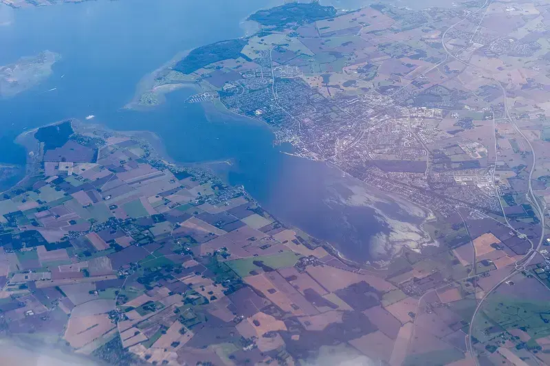 Aerial view of Holbæk Fjord with farmland and town