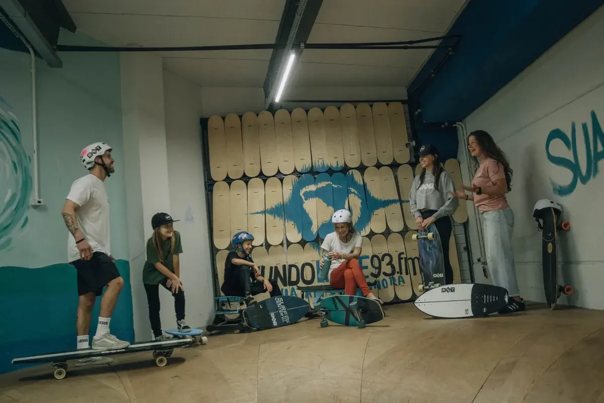 Young people with skateboards in an indoor skatepark