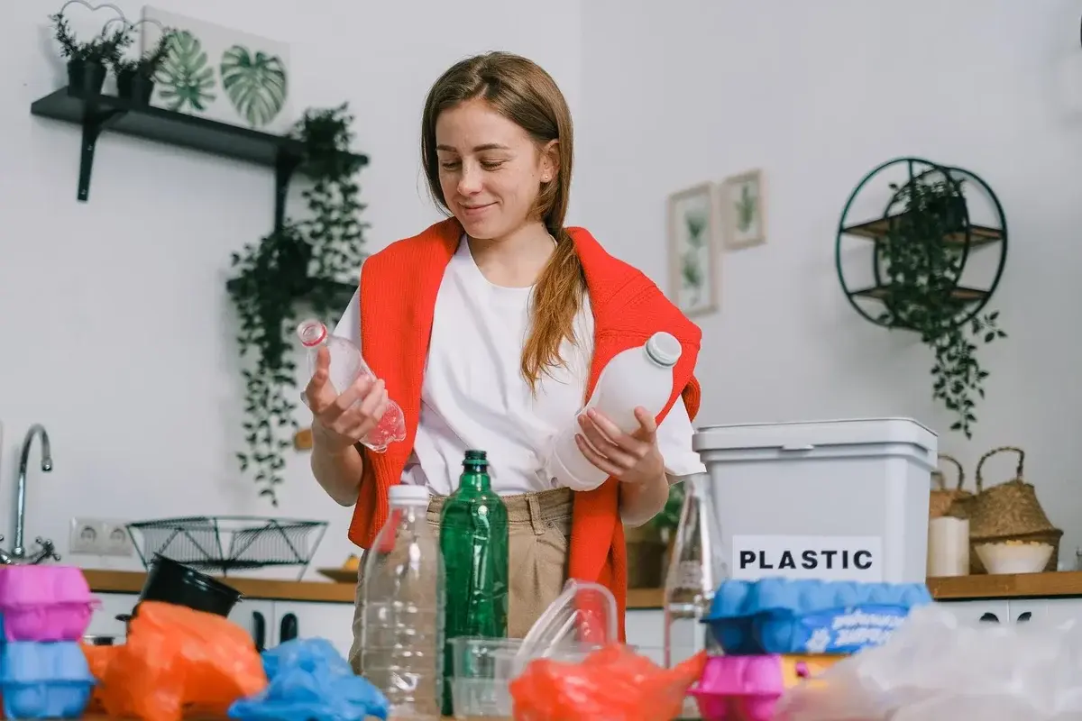 woman sorting plastic bottles in kitchen