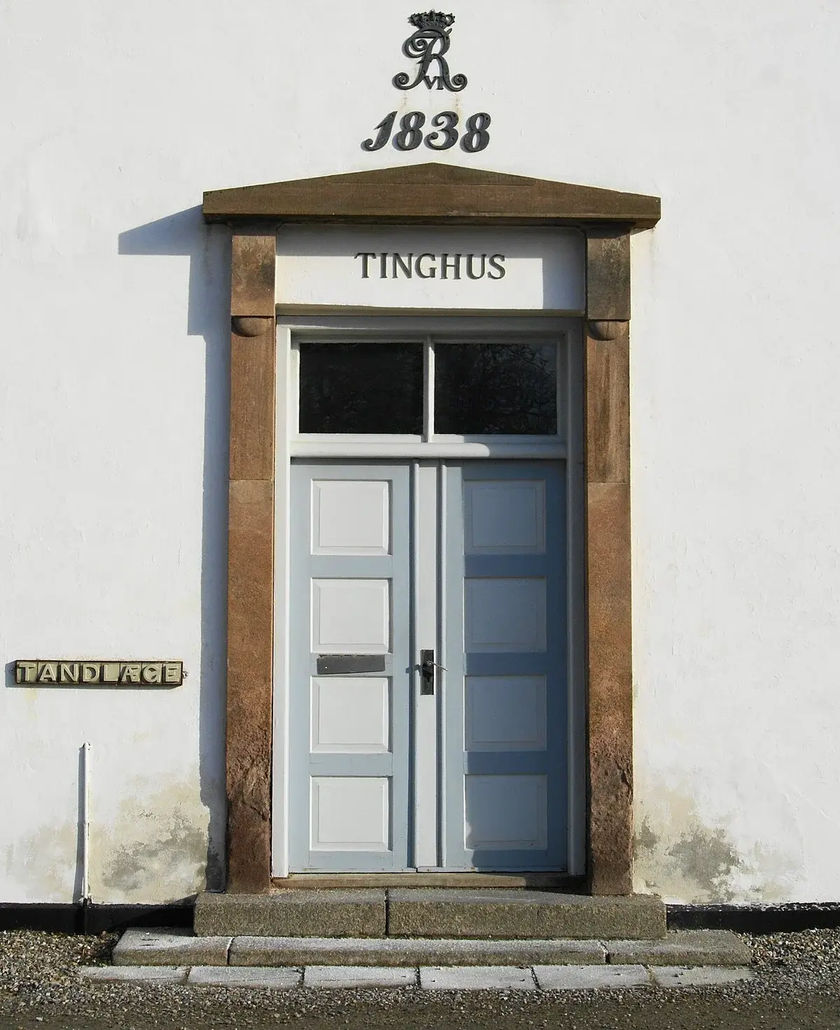 Entrance of a historic white building labeled Tinghus and 1838
