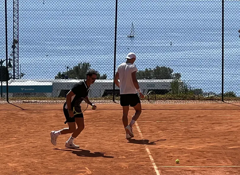 Two tennis players practicing on clay court