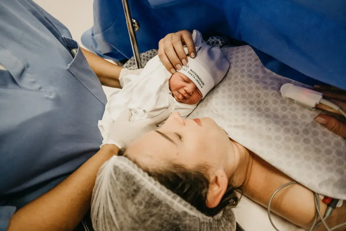 Mother holding her newborn in a hospital delivery room right after birth