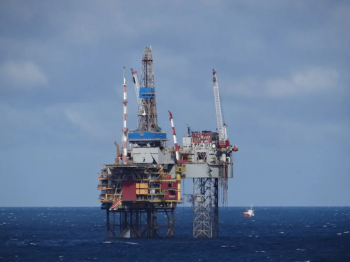 An offshore gas platform in the North Sea with a small boat nearby.