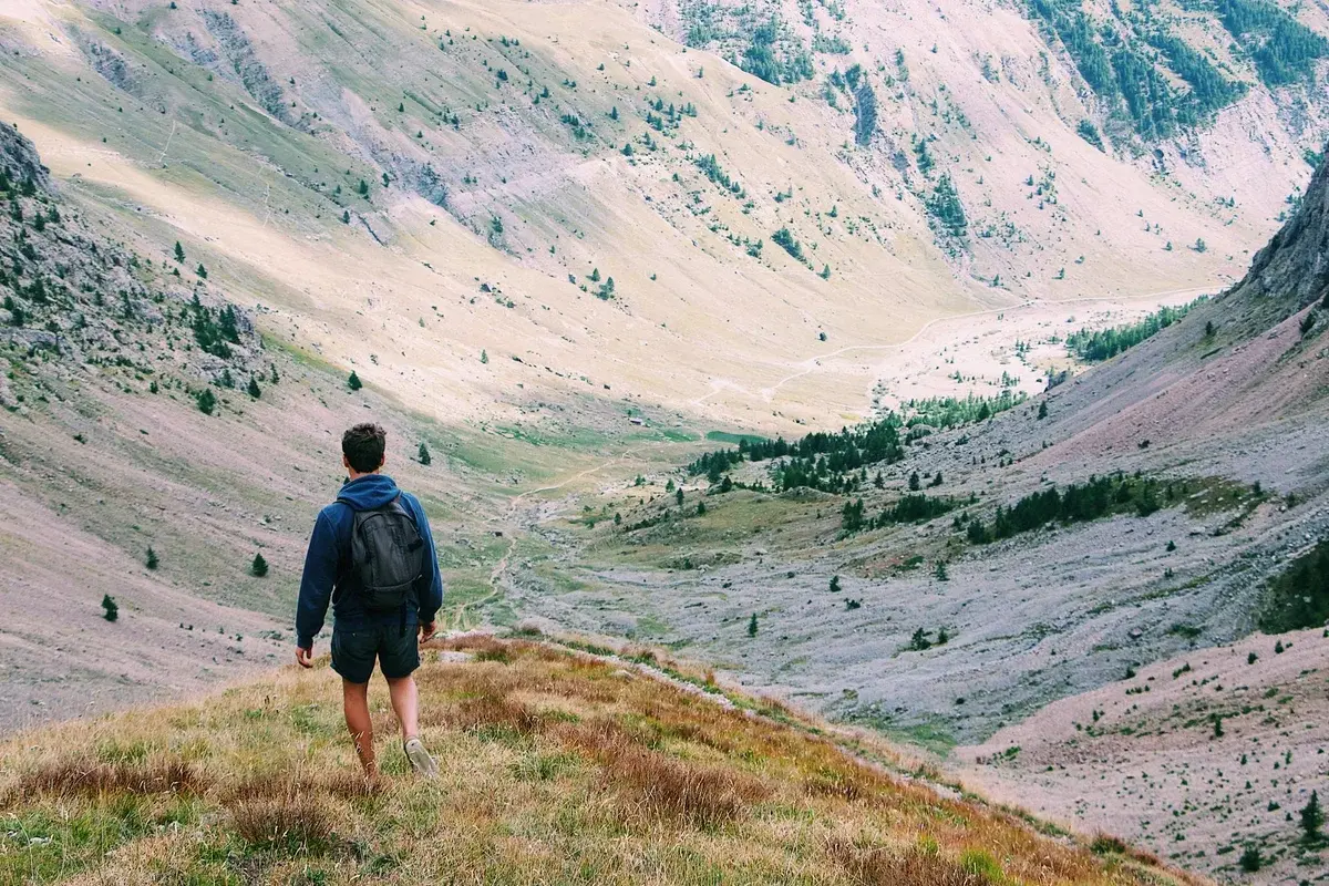 solitary hiker walking in mountain valley