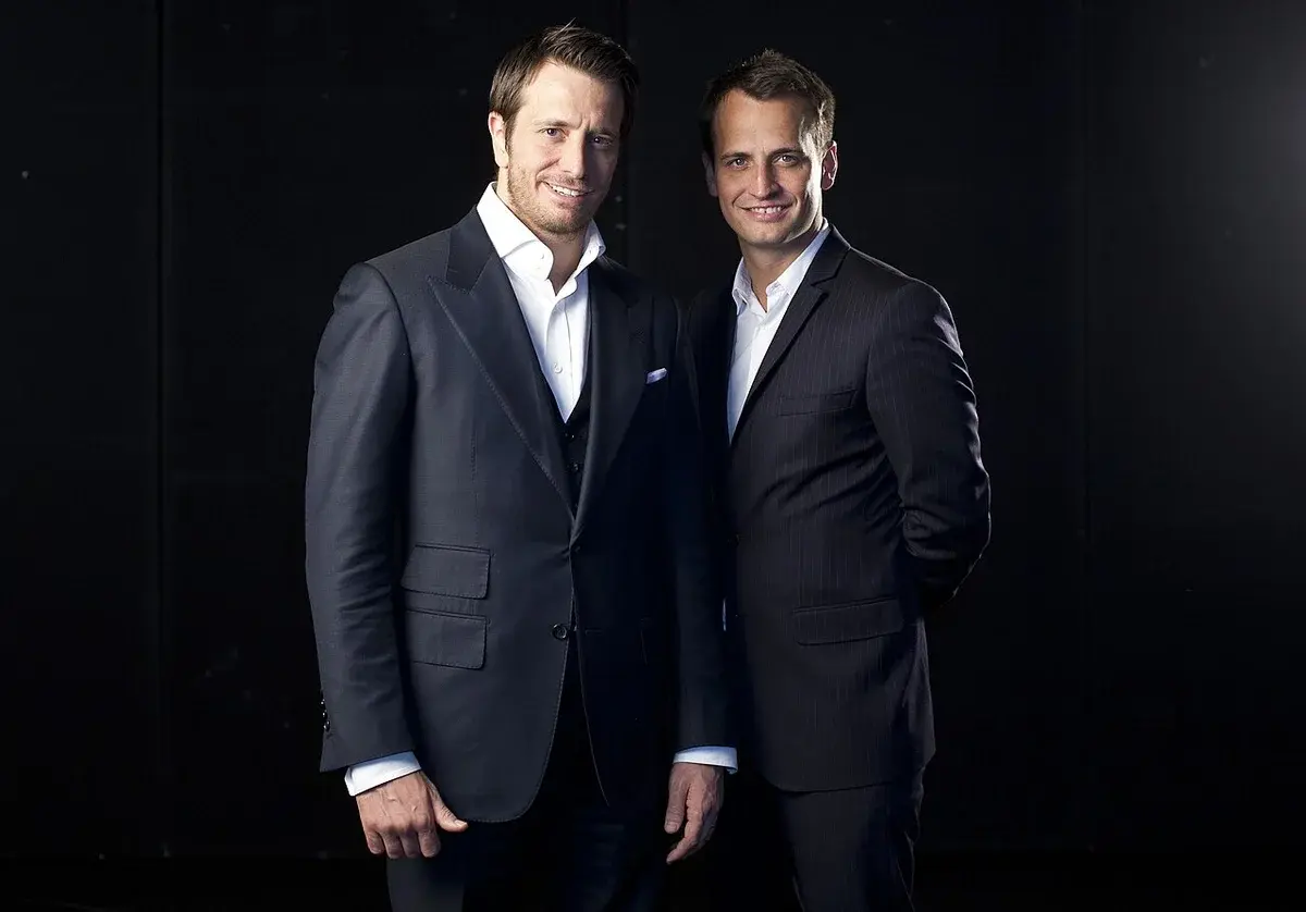 Two men in suits posing together for a portrait.
