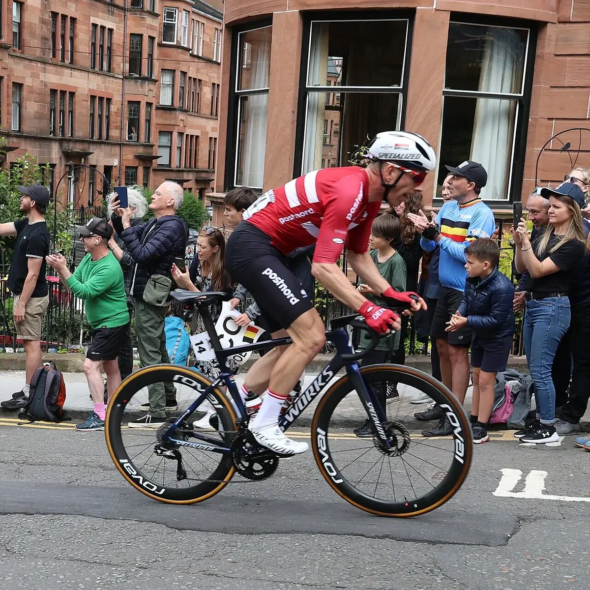 A Danish cyclist racing uphill past spectators at the UCI Road World Championships in Glasgow.