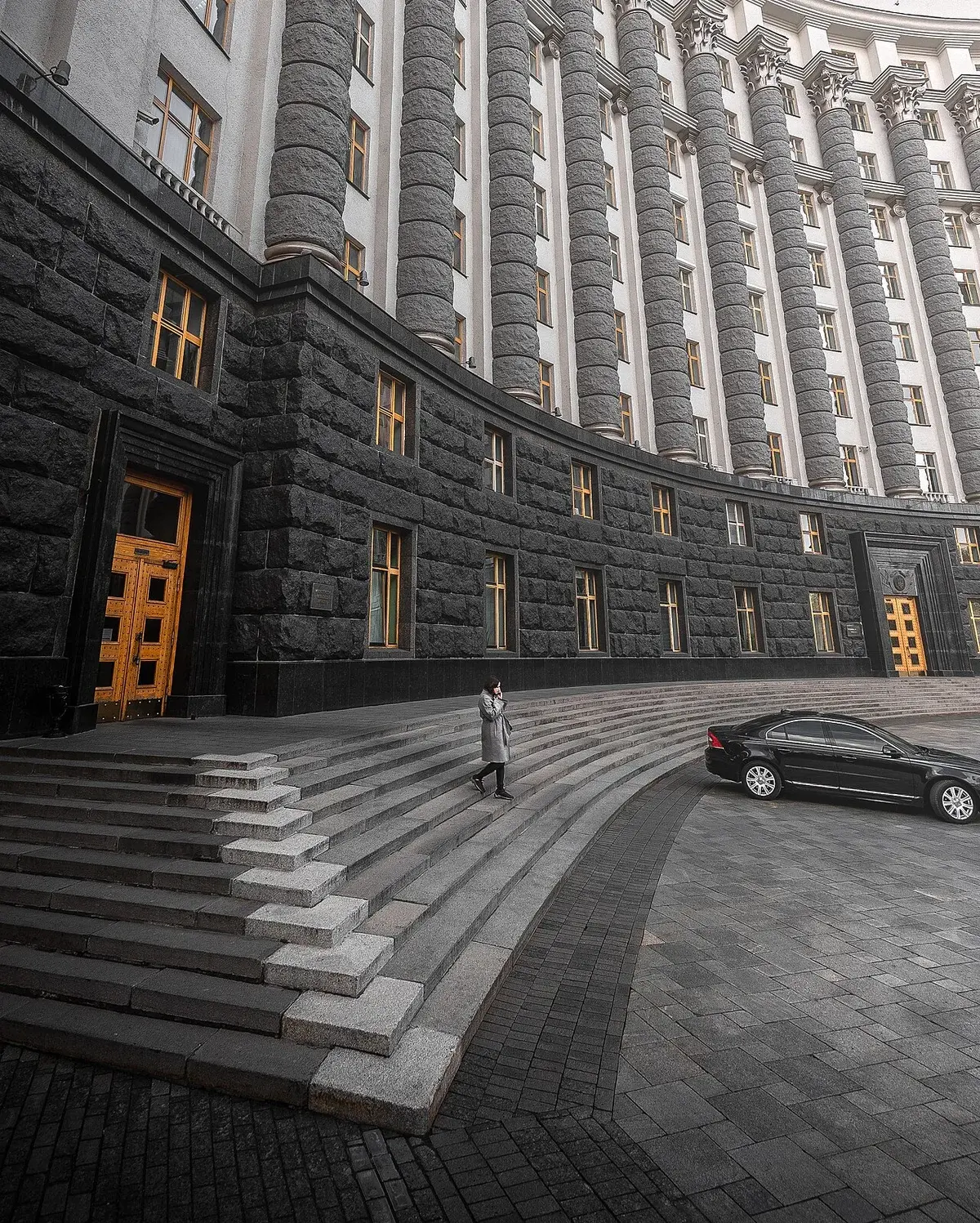 Exterior of a large government building in Kyiv with curved steps and a parked car.