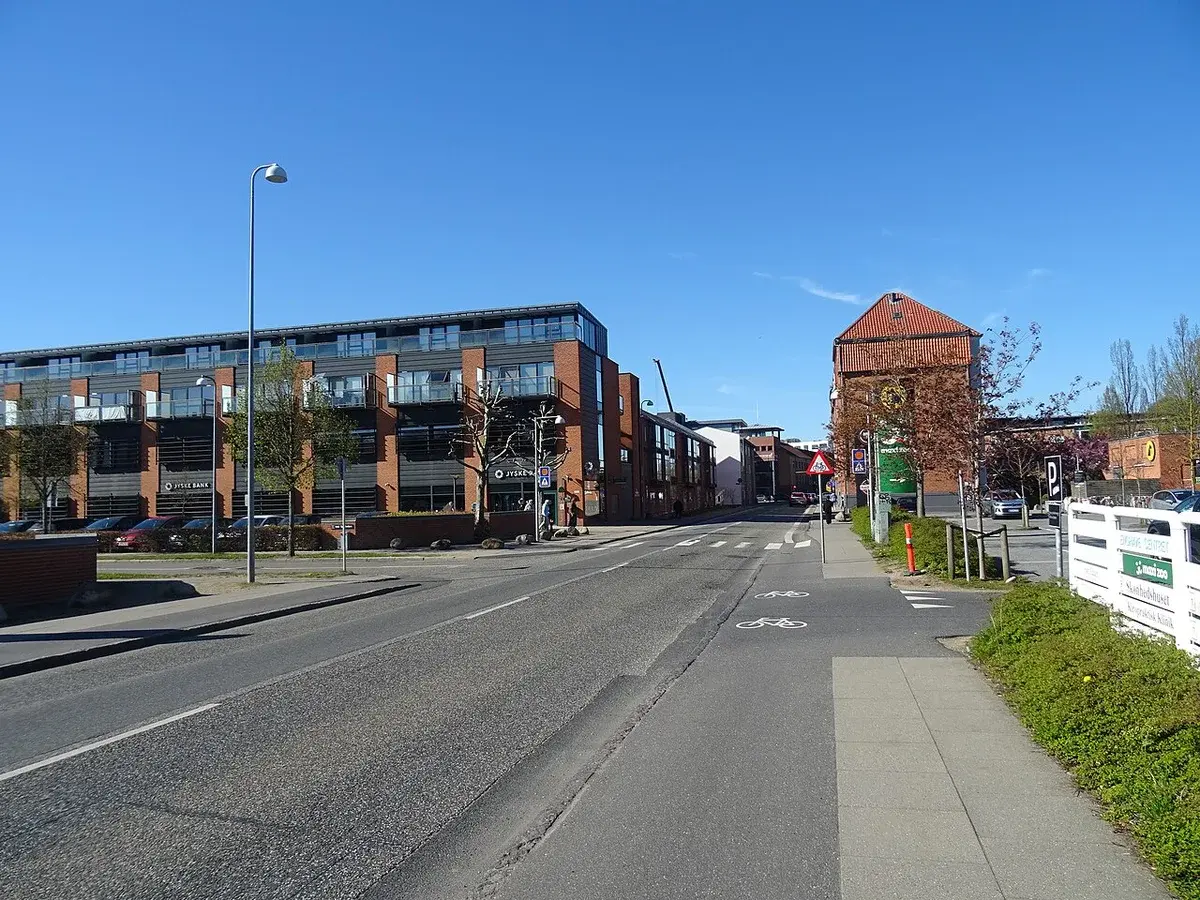 A quiet street in Vejle with modern buildings and a bike lane.